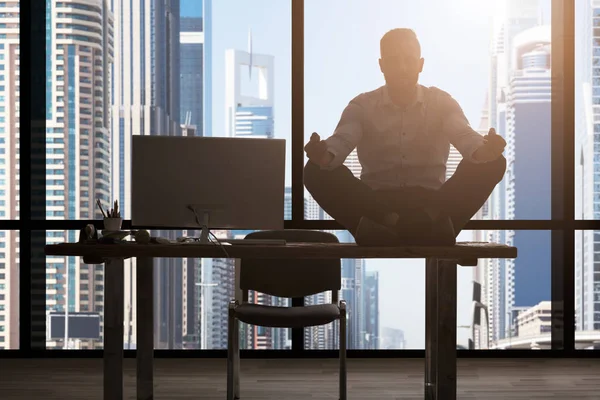 Jovem empresário meditando no escritório — Fotografia de Stock