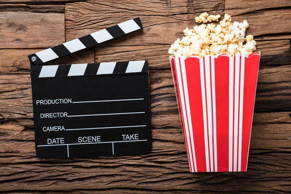 Clapperboard i Popcorn na drewno — Zdjęcie stockowe