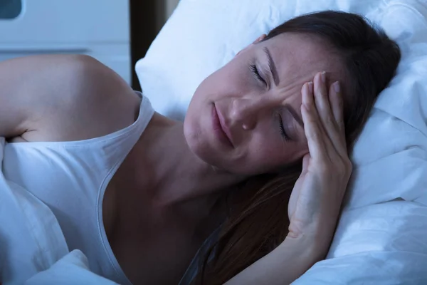 Mulher na cama com dor de cabeça — Fotografia de Stock