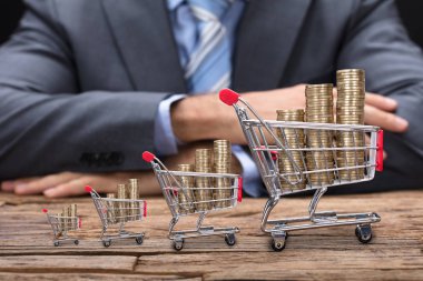 Alışveriş sepetlerini içinde paralar ile işadamı