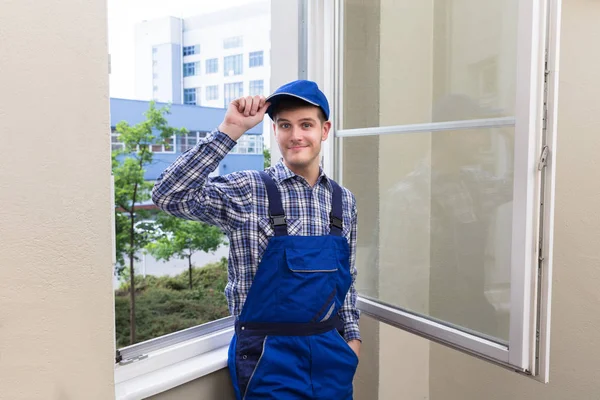 Männlicher Heimwerker steht am Fenster — Stockfoto