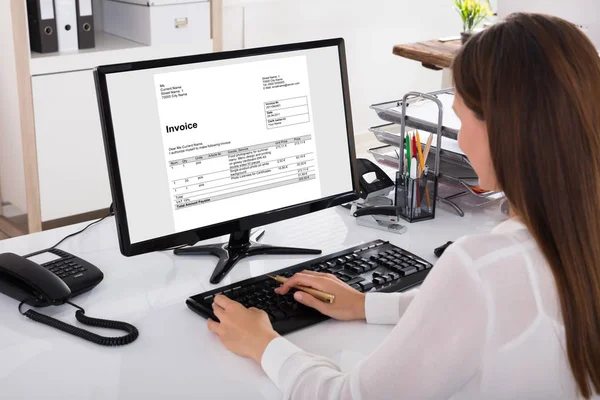 Geschäftsfrau schaut auf Rechnung am Computer — Stockfoto