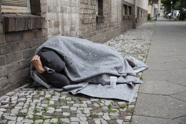 ホームレスの男が路上で寝ている — ストック写真