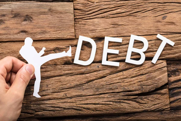 Figura Kicking Debt Word — Fotografia de Stock
