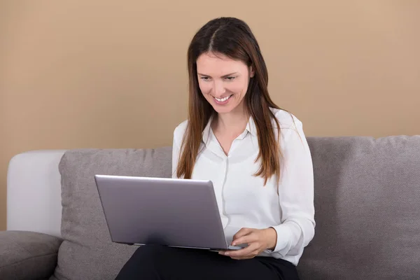 Γυναίκα κάθεται με φορητό υπολογιστή — Φωτογραφία Αρχείου