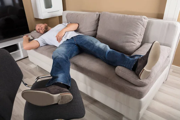 Мужчина спит на диване — стоковое фото