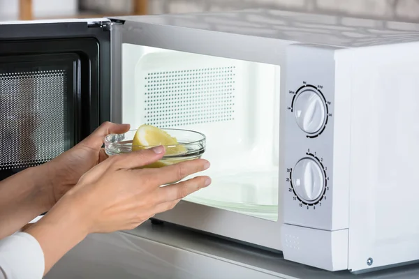 Woman Putting Lemon In Oven — Stock Photo, Image