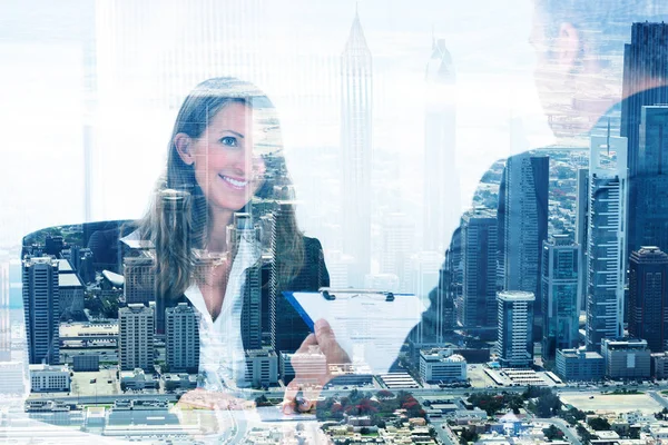 Double exposure of businesswoman looking at colleague in office over city background