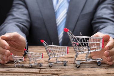 Alışveriş sepetlerini kapsayan iş adamı 