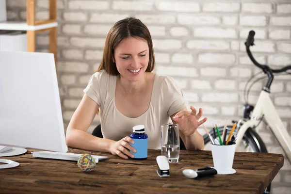 Frau steckt Pille ins Glas — Stockfoto