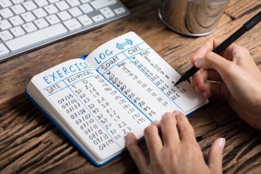 İnsan eli egzersiz günlük defter üzerinde doldurma