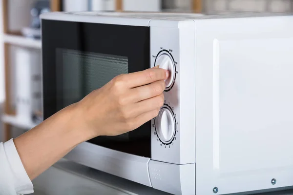 Mulher usando forno de microondas — Fotografia de Stock