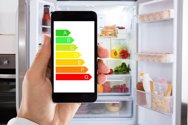 Cep Telefonu Evde Buzdolabı Karşı Enerji Etiketi Kullanarak Elini Closeup — Stok fotoğraf