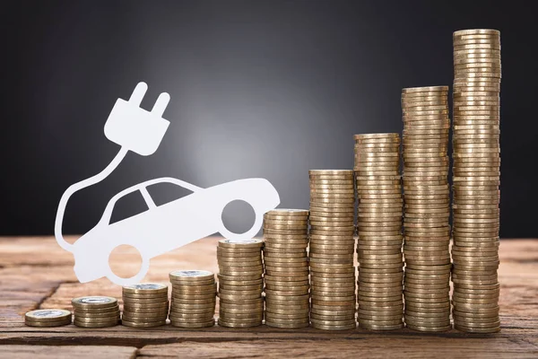 Electric Car Against Stacked Coins — Stock Photo, Image