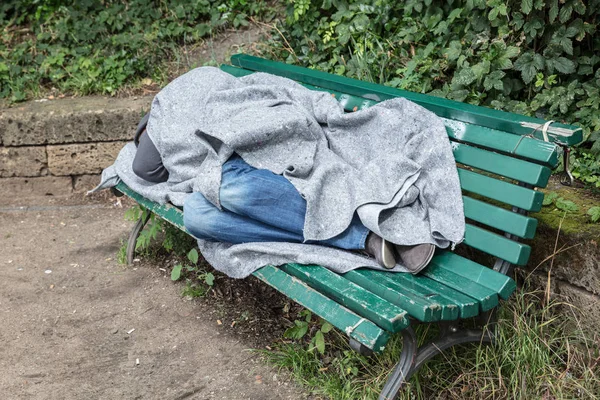 Homem sem-teto dormindo no banco — Fotografia de Stock