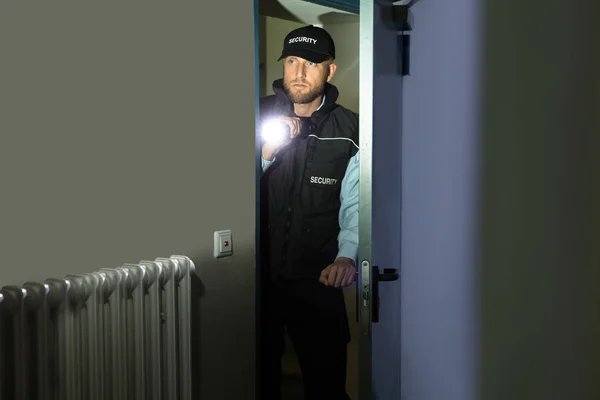 Guarda de segurança com lanterna — Fotografia de Stock