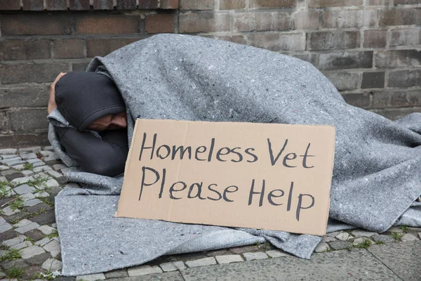 Мужчина бездомный сидящий на улице — стоковое фото