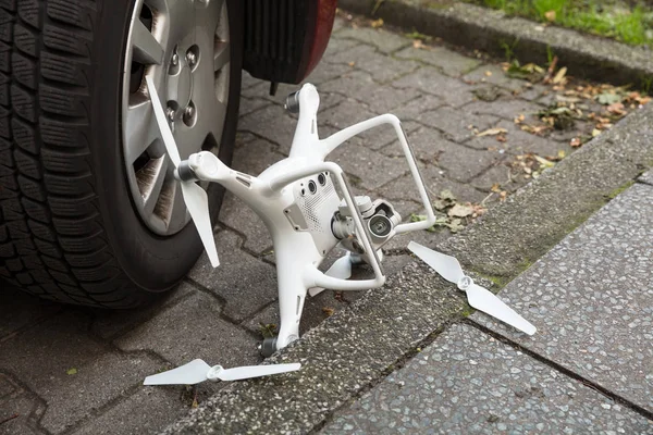 Broken drone by car — Stock Photo, Image