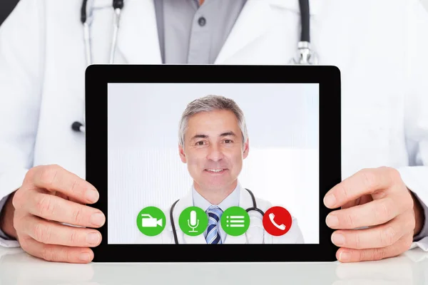 デジタル タブレットの病院での上司との電話会議を持つ男性医師の中央部 — ストック写真