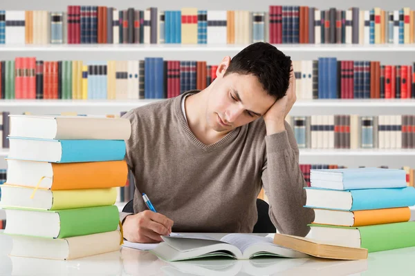 Stressvolle Universiteitsstudent Studeert Voor Boekenplank Bij Bibliotheek — Stockfoto