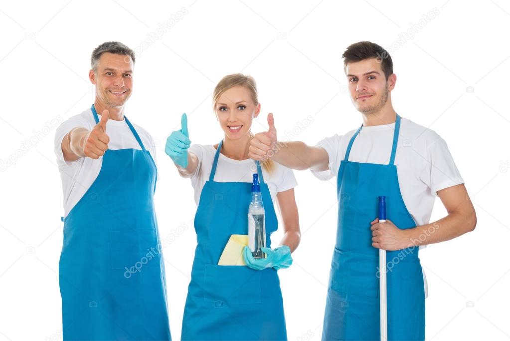 Portrait Of Happy Janitors Showing Thumb Up Sign Against White Background