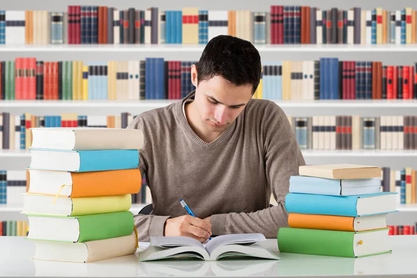 Jonge Mannelijke Universiteitsstudent Studeren Voor Boekenplank Bij Bibliotheek — Stockfoto