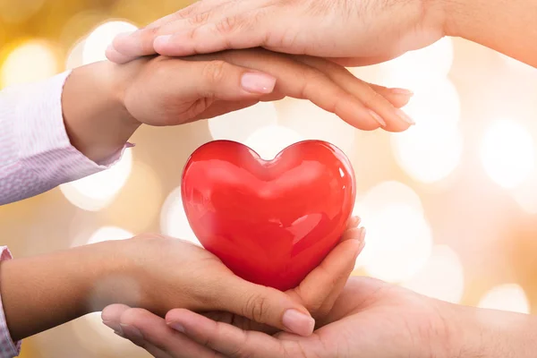 Χέρια φροντίδα κόκκινου σχήμα καρδιάς — Φωτογραφία Αρχείου