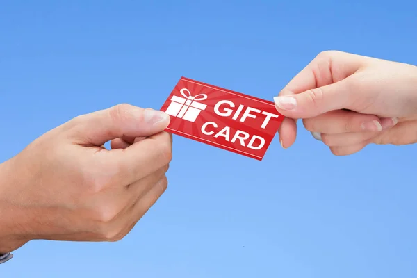 Manos sosteniendo tarjeta de regalo — Foto de Stock