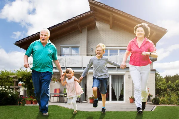 Sonriendo Abuelos Corriendo Con Sus Nietos Frente Casa —  Fotos de Stock