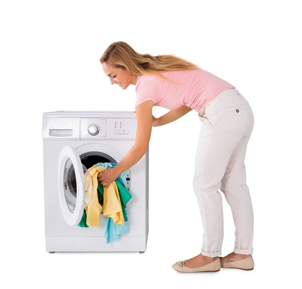 Jovem mulher colocando lavanderia — Fotografia de Stock