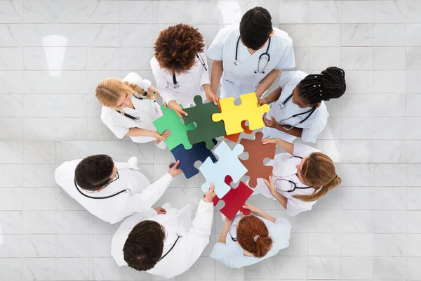 Lekarze posiadający kolorowe puzzle — Zdjęcie stockowe