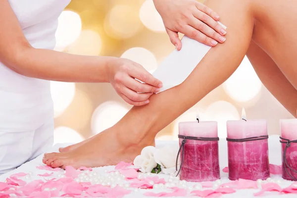 Terapeuta woskowanie kobiece nogi — Zdjęcie stockowe