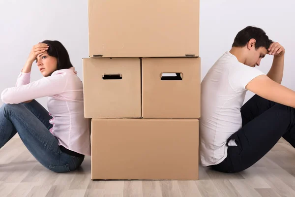 Casal cansado perto de caixas — Fotografia de Stock