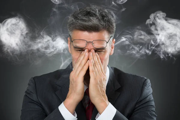 Uomo d'affari che copre la bocca dal fumo — Foto Stock