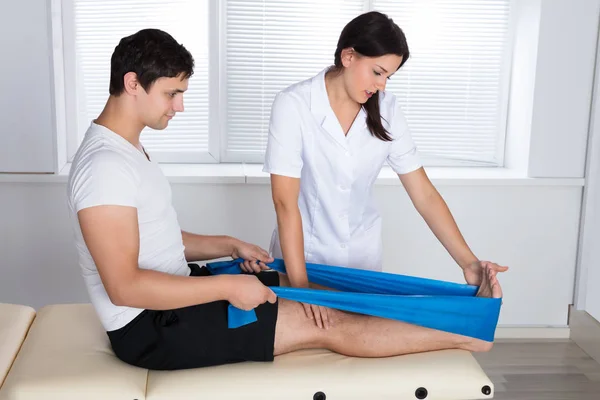 Fisioterapeuta ajudando paciente — Fotografia de Stock