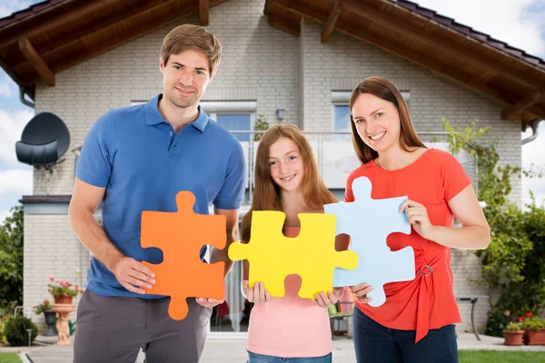 Familia sosteniendo rompecabezas — Foto de Stock