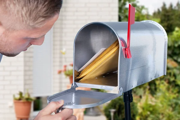 Человек, открывающий почтовый ящик — стоковое фото