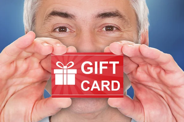 Hombre sosteniendo tarjeta de regalo — Foto de Stock