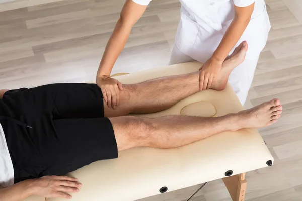 Physiotherapist Massaging Man 's Leg — стоковое фото