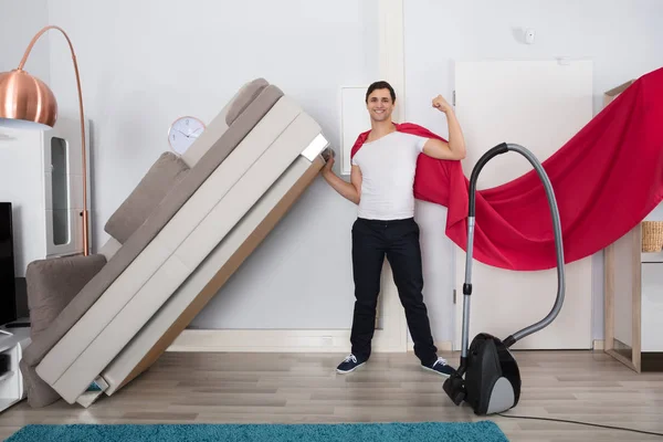 Homem mais limpo levantando sofá — Fotografia de Stock