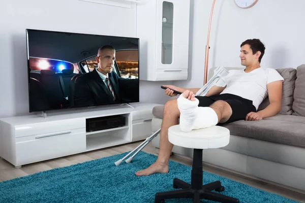 Hombre lesionado viendo la televisión — Foto de Stock