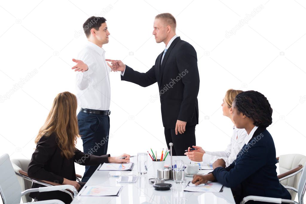 Boss Shouting On Male Executive In Business Meeting