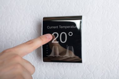 Person Touching Thermostat  clipart