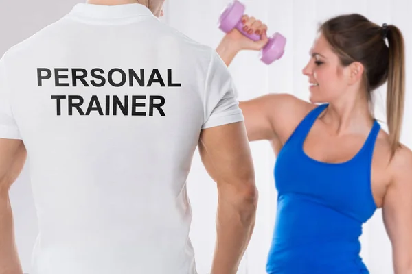 Jovem Mulher Fazendo Exercício Com Halteres Frente Personal Traininer — Fotografia de Stock