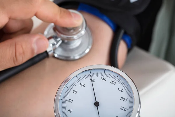 Médico verificando a pressão arterial — Fotografia de Stock