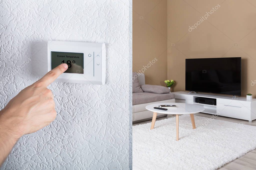 Person Adjusting Digital Thermostat