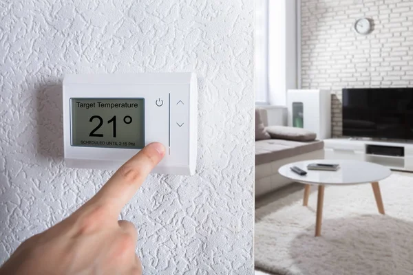 Person stellt digitales Thermostat ein — Stockfoto