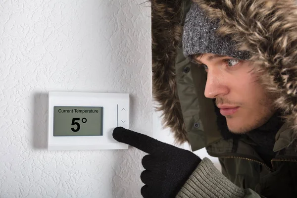 Homem ajustando a temperatura ambiente — Fotografia de Stock