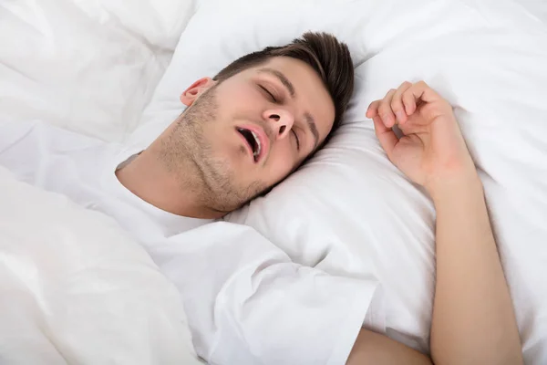 Trøtt ung mann Snoring – stockfoto