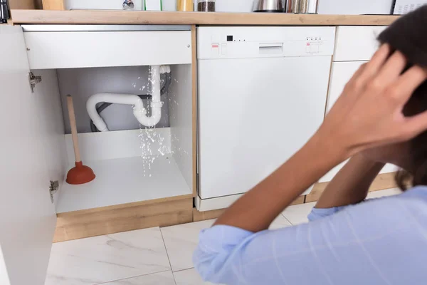 Woman Looking At Leaking Sink Pipe — Stock Photo, Image